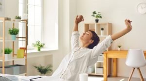 a woman taking a break and stretching while working at home